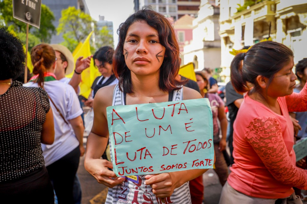 Mulher indígena mostra cartaz em manifestação intercultural.
Fonte: CPERS / Sindicato 